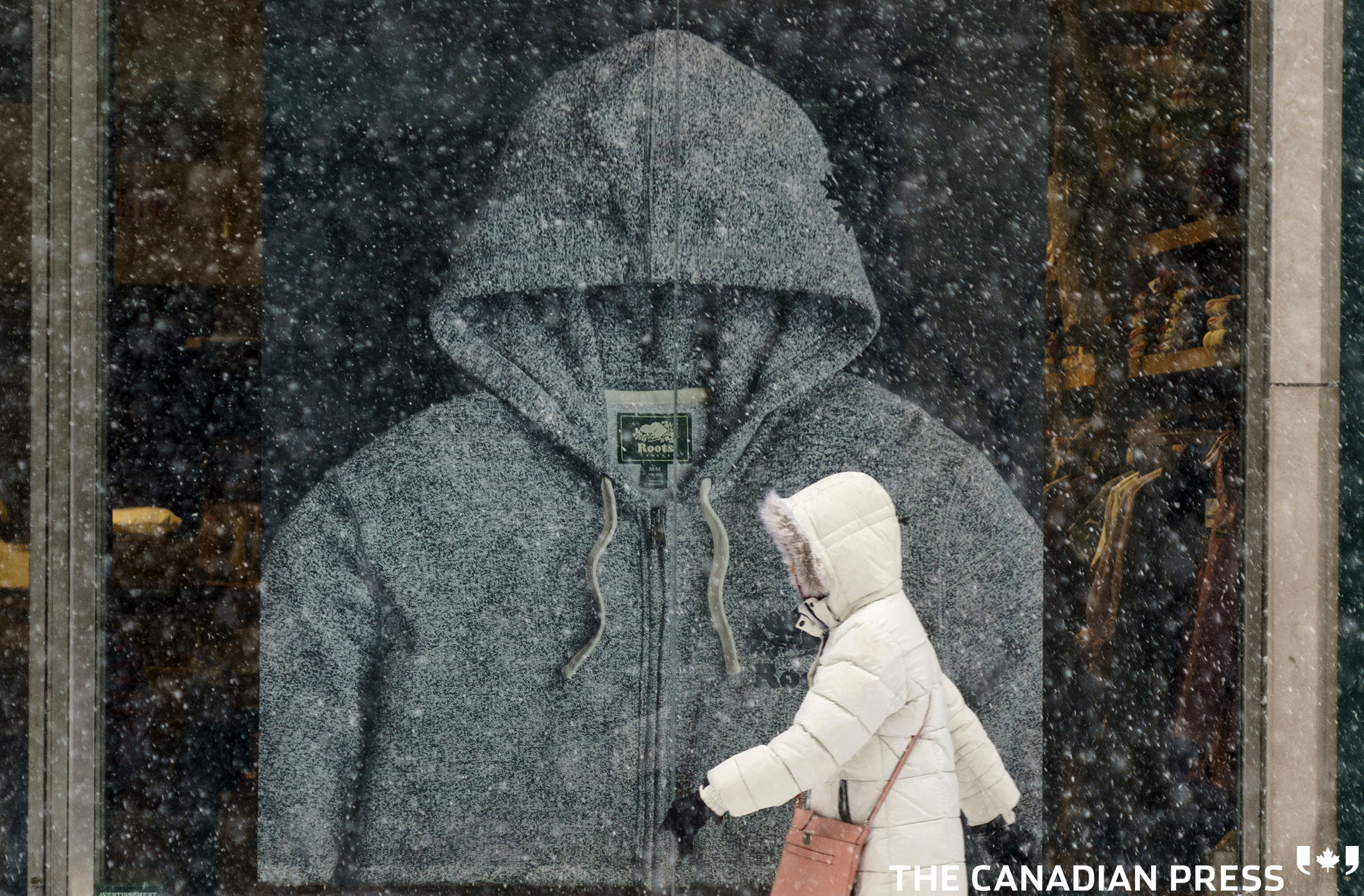 A pedestrian walks down Saint-Catherine street during a snowstorm in Montreal, on Tuesday, February 2, 2021. Quebec Premier François Legault is expected to announce a loosening of some restrictions including the reopening of non-essential businesses province-wide. THE CANADIAN PRESS/Paul Chiasson