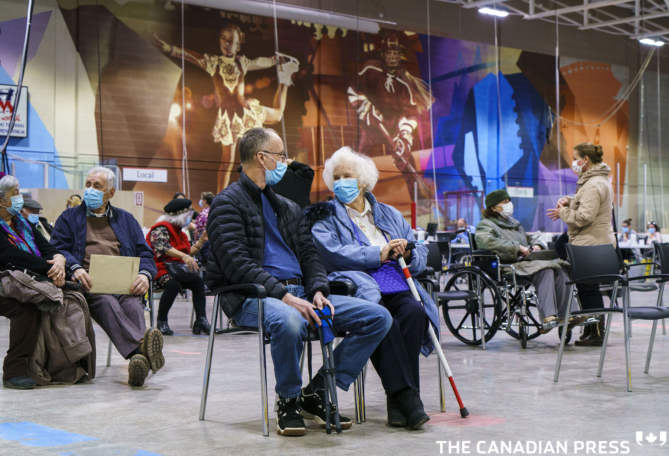 Seniors wait after receiving a first dose of COVID-19 vaccine at a vaccination clinic in a hockey arena in Montreal, on Wednesday, March 10, 2021. THE CANADIAN PRESS/Paul Chiasson
