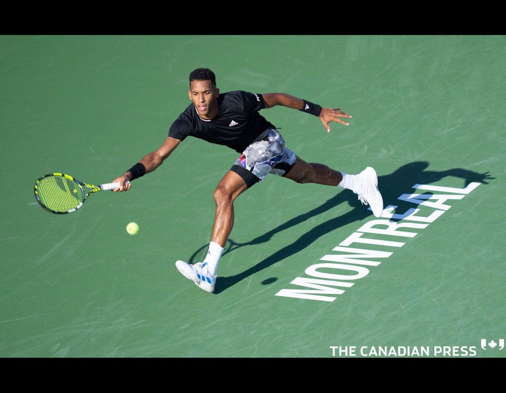 Canada’s Felix Auger-Aliassime lunges to return the ball to Cameron Norrie of Great Britain during round of sixteen play at the National Bank Open tennis tournament, Thursday, August 11, 2022 in Montreal. THE CANADIAN PRESS/Paul Chiasson